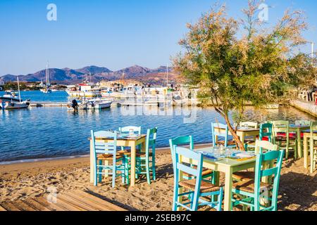 Tische und Stühle in einem typisch griechischen Tavernen-Restaurant im Hafen von Pollonia, Insel Milos, Kykladen, Griechenland Stockfoto