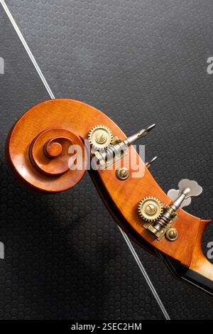 Nahaufnahme eines Kontrabass-Kopfstocks, wahrscheinlich in einem Musikstudio. Die Einstellstifte und der Zahnradmechanismus sind sichtbar. Stockfoto