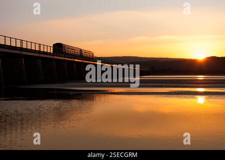 Der Supersprinterzug der Nordbahn der Klasse 156 überquert den Arnside Viadukt auf der landschaftlich reizvollen Cumbrian Coast Railway, die in der untergehenden Sonne glitzert Stockfoto