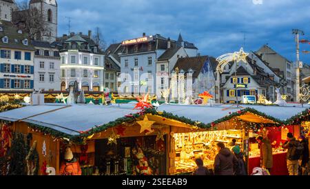 Basel, Schweiz - 23. Dezember 2024: Eine festliche Weihnachtsmarktszene mit wunderschön dekorierten Ständen, funkelnden Lichtern und einer Kulisse aus Geschichte Stockfoto