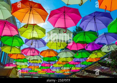 Viele bunte Regenschirme vor wolkenlosem blauen Himmel Stockfoto