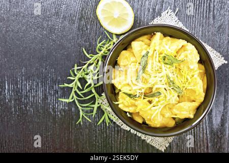 Kürbis Gnocchi mit Salbei, Zitrone, Käse und Butter in einer Schüssel auf der Leinwand gegen dunkle Holz- Brett oben Stockfoto