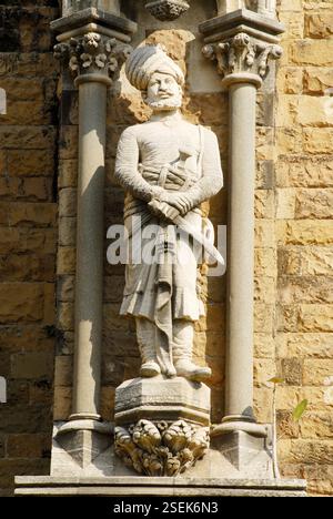 Reich geschnitzte menschliche Figur des lokalen Mannes auf dem Rajabai Turm Uhrenturm Universität von Mumbai, Bombay Mumbai, Maharashtra, Indien UNESCO-Weltkulturerbe Stockfoto
