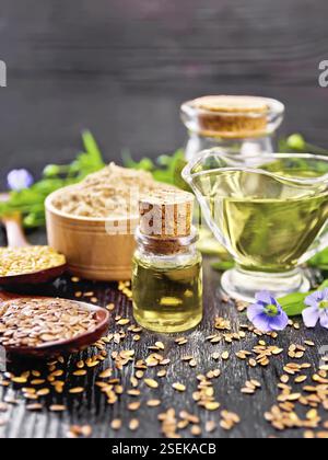 Leinöl in zwei Gläser und eine Sauciere mit weißen und braunen Leinsamen in Löffel Mehl in eine Schüssel, Blätter und Blüten auf Holzbrett backgrou Stockfoto