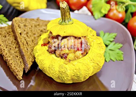 Squash gelb gefüllt mit Fleisch, Tomaten und Paprika, Brot in einen braunen, Tomaten, Petersilie auf einem hölzernen Brettern Hintergrund Stockfoto