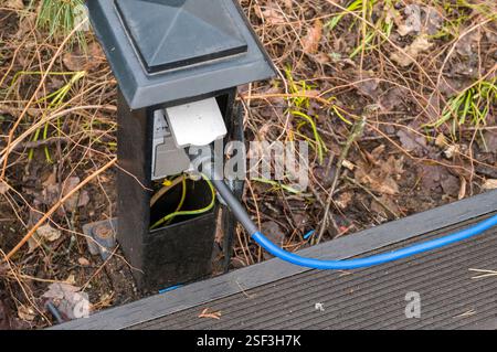 Wasserdichte Außenbuchse und Stecker am Boden montiert, eine Tageslichtaufnahme Stockfoto