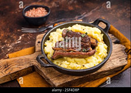 Nahaufnahme mit zarten, karamellisierten Rippchen aus Rindfleisch, die auf einem Bett aus cremigem Kartoffelpüree ruhen und eine einladende kulinarische Szene schaffen. Braun Stockfoto