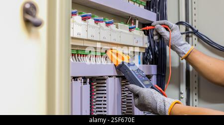 Ein Elektriker prüft die Funktion des Schaltschranks. Stockfoto
