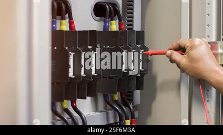 Ein Elektriker prüft die Funktion des Schaltschranks. Stockfoto
