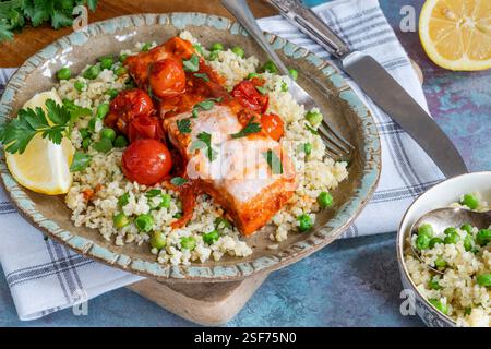 Harissa-Lachs mit Bulgur-Weizen, Kirschtomaten und grünen Erbsen Stockfoto