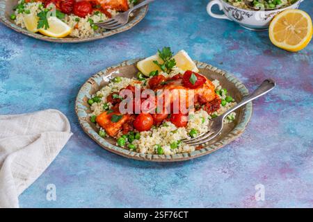 Harissa-Lachs mit Bulgur-Weizen, Kirschtomaten und grünen Erbsen Stockfoto