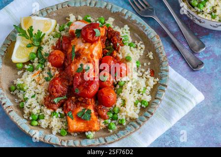 Harissa-Lachs mit Bulgur-Weizen, Kirschtomaten und grünen Erbsen Stockfoto