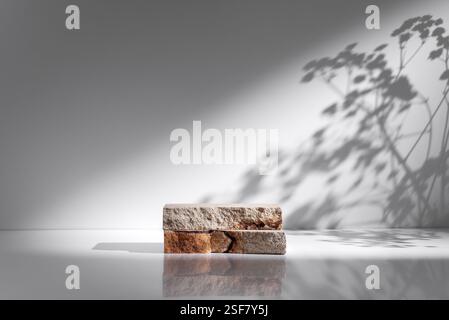 Produktanzeige mit Natursteinblöcken auf weißer Oberfläche und weichen Schatten. Minimalistisches Design für Branding- oder Präsentationsmodelle. Modern, sauber Stockfoto