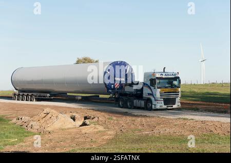 Auf dem Land parkt ein Sattelauflieger der Firma AltéAd, der in außergewöhnlichem Konvoi ein Element des Pylons einer Vestas-Windkraftanlage transportiert. Stockfoto