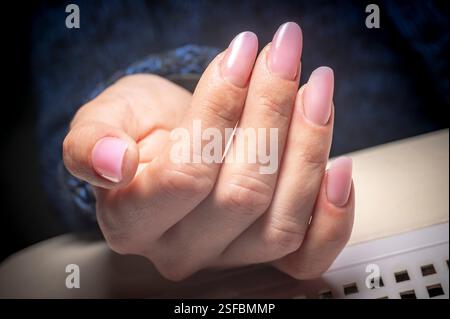 Gel-Maniküre, lange, scharfe Nägel mit modernem Design, von einem professionellen Techniker gemacht. Stockfoto