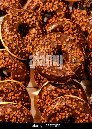 Schokoladen-Donuts mit Streuseln an einem Schaufenster. Stockfoto
