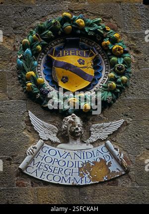 Wappen des Florentiner Kommissars in Volterra, Toskana, Italien. Medaillon, das an der Fassade des Palazzo dei priori ausgestellt ist, erinnert an die Herrschaft von Florenz und den Medici nach der Eroberung von Volterra durch Florenz im Jahr 1472. Stockfoto
