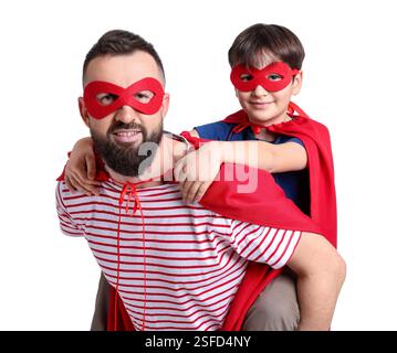 Vater und Sohn tragen Superheldenkostüme auf weißem Hintergrund Stockfoto