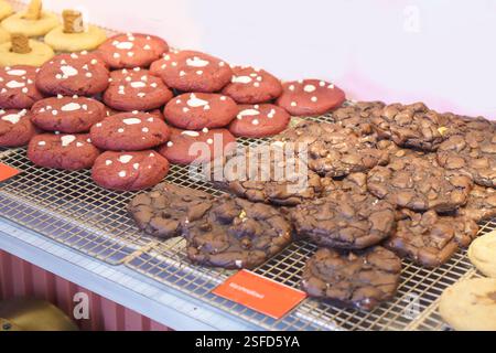 Nahaufnahme von zwei Sorten frisch gebackener Kekse mit leuchtenden roten Samtkeksen, gekrönt mit weißen Schokoladenchips und reichhaltiger Doppel-Chocol Stockfoto