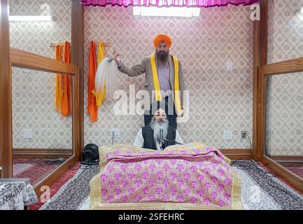 Ein Sikh winkt seinen Chaur Sahib Fliegenbesen bei einem Akhand-Pfad-Service, wo die gesamte Bibel gelesen wird. In einem Tempel in Queens, New York. Stockfoto