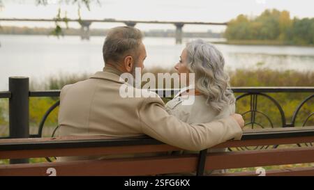 Rückansicht Happy Senior Pärchen Familie sitzen auf Bank Liebe Ruhestand reife Frau Mann genießen romantisches Date im Stadtpark Kaukasier mittleren Alters männlich Stockfoto
