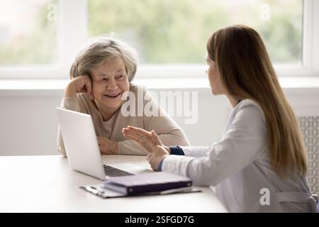 Lächelnde Großmutter im Alter mit vertrauenswürdigem Arzt Stockfoto