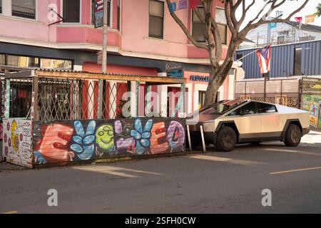 Tesla Cybertruck (3067) parkte auf einer Straße im Mission District in San Francisco, CA, in der Nähe eines lebendigen Wandgemäldes und einer überdachten Terrasse. Stockfoto