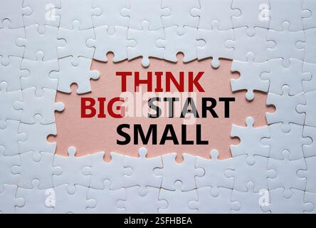 Denken Sie an das große Anfang-kleine Symbol. Konzeptworte denken an großen Anfang klein auf weißem Puzzle. Schöner rosafarbener Hintergrund. Business und Think Big Fang Small Conce Stockfoto