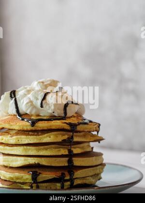 Turm von Pfannkuchen mit Sahne und Schokoladensirup. Freier Platz für Kopieren und Text. Stockfoto