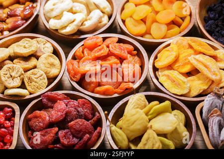 Schüsseln mit verschiedenen getrockneten Früchten auf Holztisch Stockfoto