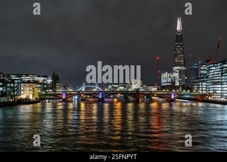 Themse: Cannon Street und Tower Bridge in London bei Nacht, wunderschön beleuchtet mit Stadtlichtern und modernen Gebäuden Stockfoto