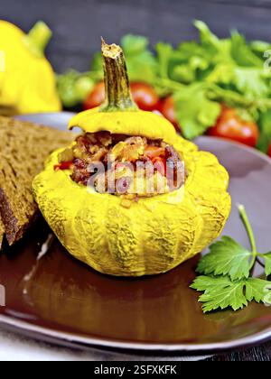 Squash gelb gefüllt mit Fleisch, Tomaten und Paprika, Brot in einen braunen, Tomaten, Petersilie auf einem dunklen Holz- Board Stockfoto
