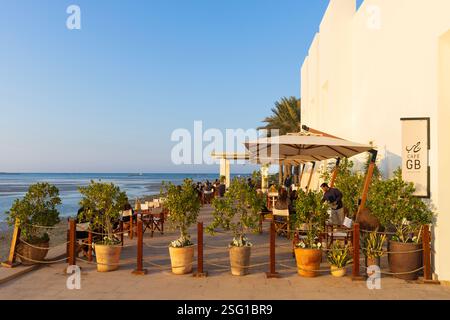 Die Leute genießen einen ruhigen Nachmittag im Café des Bahrain Fort Museum am Karabababad Beach in Manama, Bahrain Stockfoto