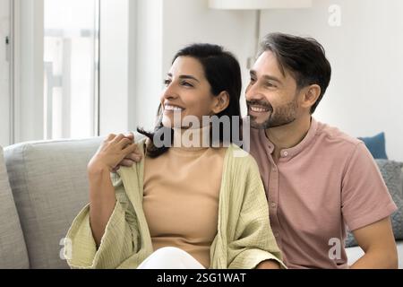 Nachdenkliches verliebtes Paar, das auf der Couch sitzt Stockfoto