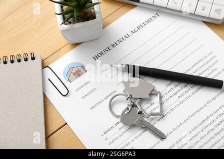 Leeres Haus Mietvertrag mit Schlüssel auf hölzernem Hintergrund, Nahaufnahme Stockfoto