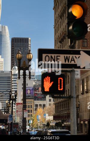 Einbahnschild, Fußgängersignal und Stadtgebäude in San Francisco, wahrscheinlich in der Nähe der Kreuzung einer Hauptstraße und einer Fußgängerüberfahrt. Stockfoto