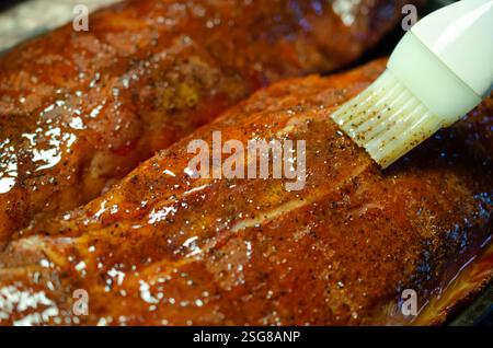 Grillrippen auf dem Grill. Köstliches Fleisch, zubereitet mit Sauce und Gewürzen für vollen Geschmack. Protein für saftiges Hauptgericht oder Snack. Stockfoto