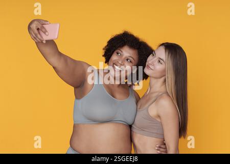 Selfie mit Smartphones vor gelbem Hintergrund Stockfoto