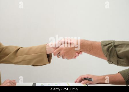 Asiatische Paare handschütteln und unterzeichnen Vertragsfinanzdokumente unter Anleitung eines Beraters zu Hause, Zusammenarbeit und durchdachte Planung für Finanzen Stockfoto