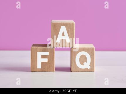 Drei Holzwürfel mit weißen Buchstaben bilden das Akronym FAQ, häufig gestellte Fragen. Stockfoto