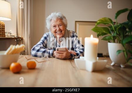 Ältere Frau, die sich beim Gebrauch des Smartphones selbstbewusst fühlt. Stockfoto