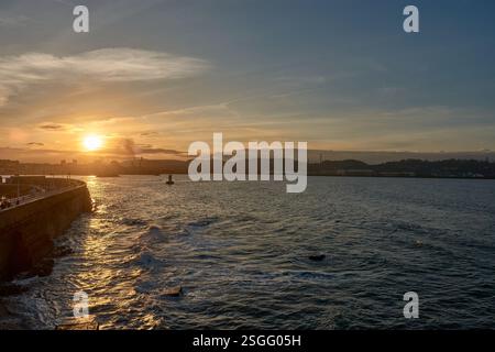 Das Bild zeigt die Sonne, die anmutig zum Horizont hinabsteigt und ein warmes goldenes Leuchten über die weite Weite des Meeres wirft. Stockfoto