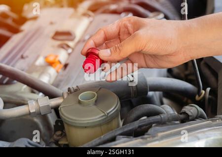 Bild der Hand des Autoverarbeiters, der das Fahrzeug in der Garage repariert. Wartungsarbeiten an der Fahrzeugwartung. Selektiver Fokus. Stockfoto