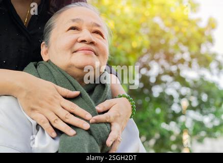 Schuss von den Händen der erwachsenen Tochter, die ihre Mutter im Herbstpark umarmen. Nahaufnahme, Kopierbereich. Stockfoto