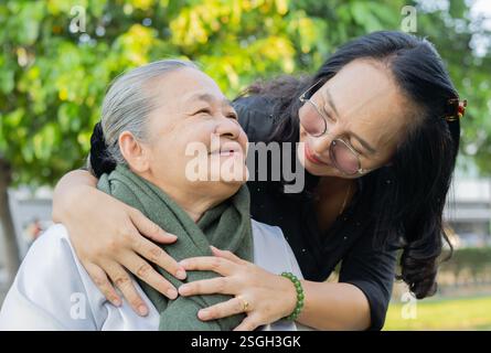 Portraitbild einer älteren asiatischen Frau, die Spaß hat, mit einer glücklichen Tochter im Park zu reden. Stockfoto
