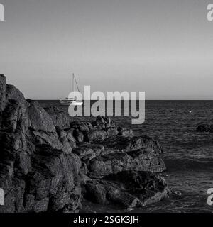 Ein Boot vor Anker in einer friedlichen felsigen Bucht Stockfoto