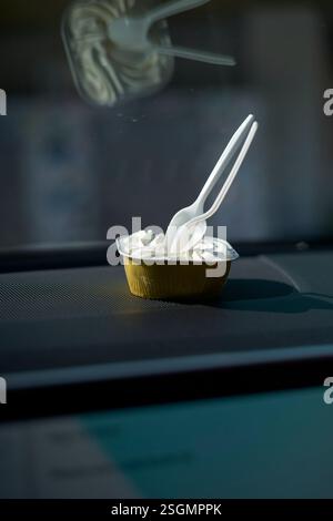 Gebäckbecher mit Plastiklöffeln auf einem Armaturenbrett im Sonnenlicht, Florida Keys, USA Stockfoto