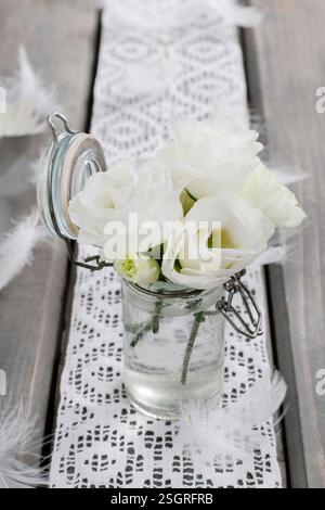 Winziger Strauß weißer Eustoma-Blüten. Partydekor Stockfoto