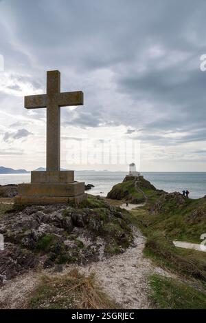 TWR Mawr Leuchtturm und altes Steinkreuz an der Spitze von Ynys Llanddwyn, einer kleinen Insel auf Anglesey, Nordwales. Stockfoto