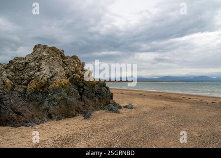Felsen bilden sich am Newborough Beach in Anglesey, Nordwales. Stockfoto